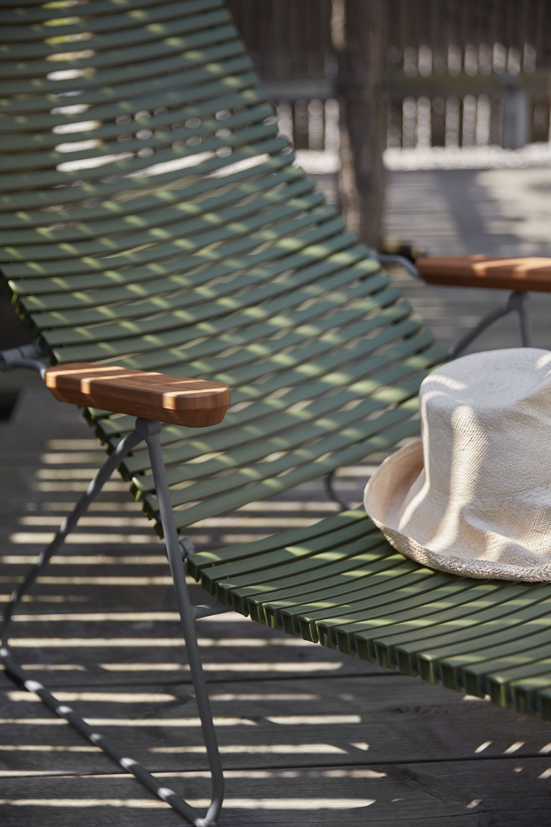 Detailaufnahme des Houe Click Sunlounger Liegestuhl auf einer sonnigen Terrasse mit Hut.