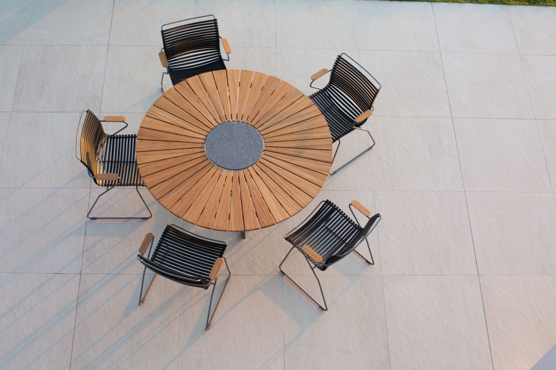 Houe Click Dining Armlehnstühle mit niedriger Lehne stehen um einen Houe Circle Tisch.