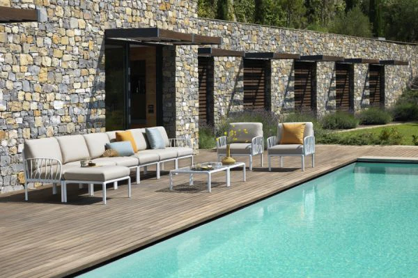 Stilvolle Outdoor-Sitzgruppe am Pool vor einem Natursteingeb&auml;ude