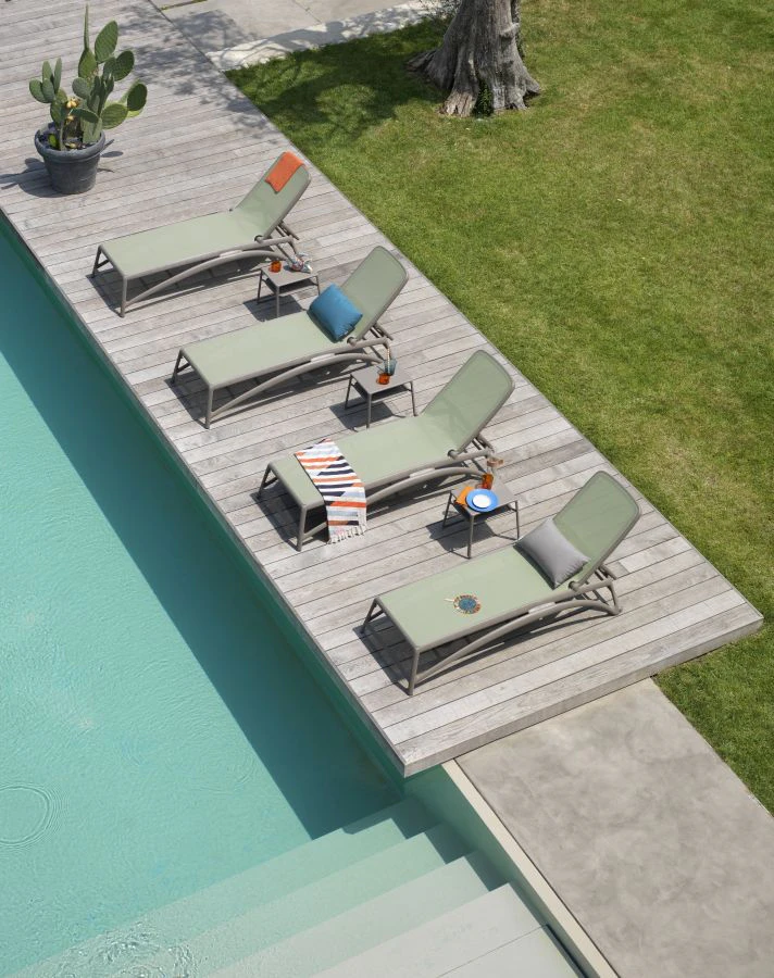 Gem&uuml;tliche Sonnenliegen auf einer Holzterrasse an einem Pool