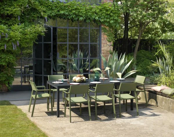 Design-Gartenm&ouml;bel-Set auf Terrasse vor begr&uuml;nter moderner Architektur
